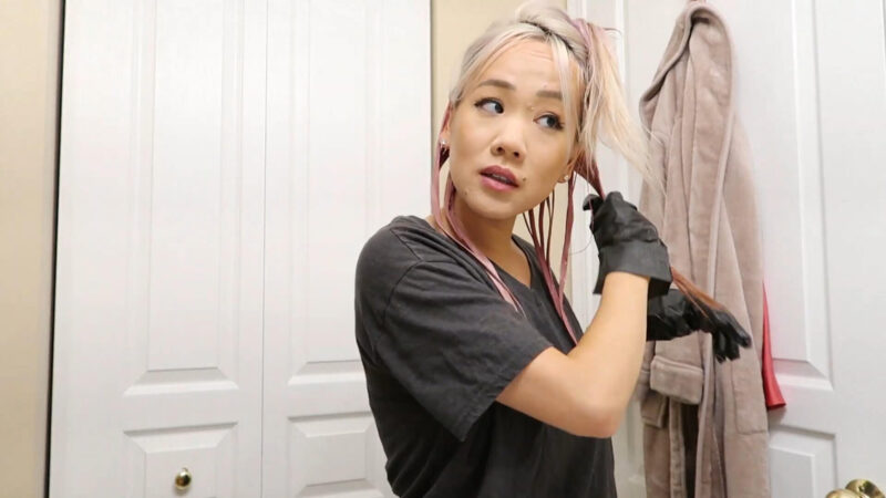 Girl applying pink semi-permanent hair color to her hair