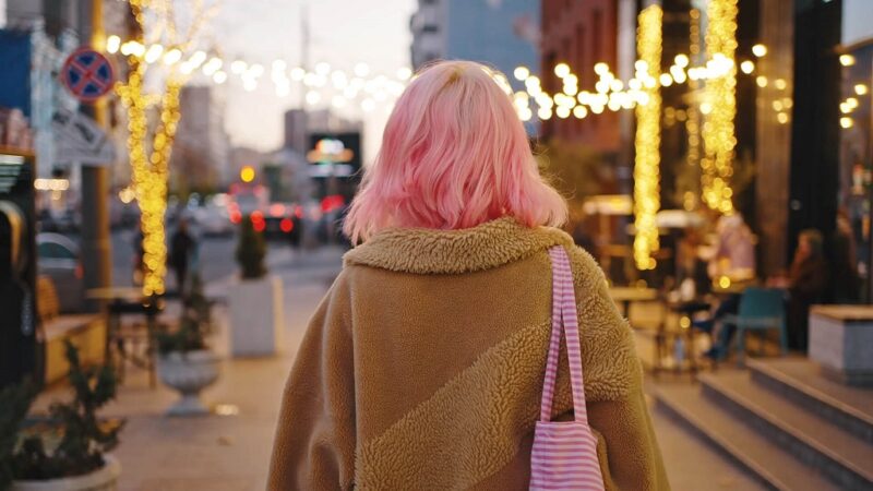 Girl with pink hair walking around the city